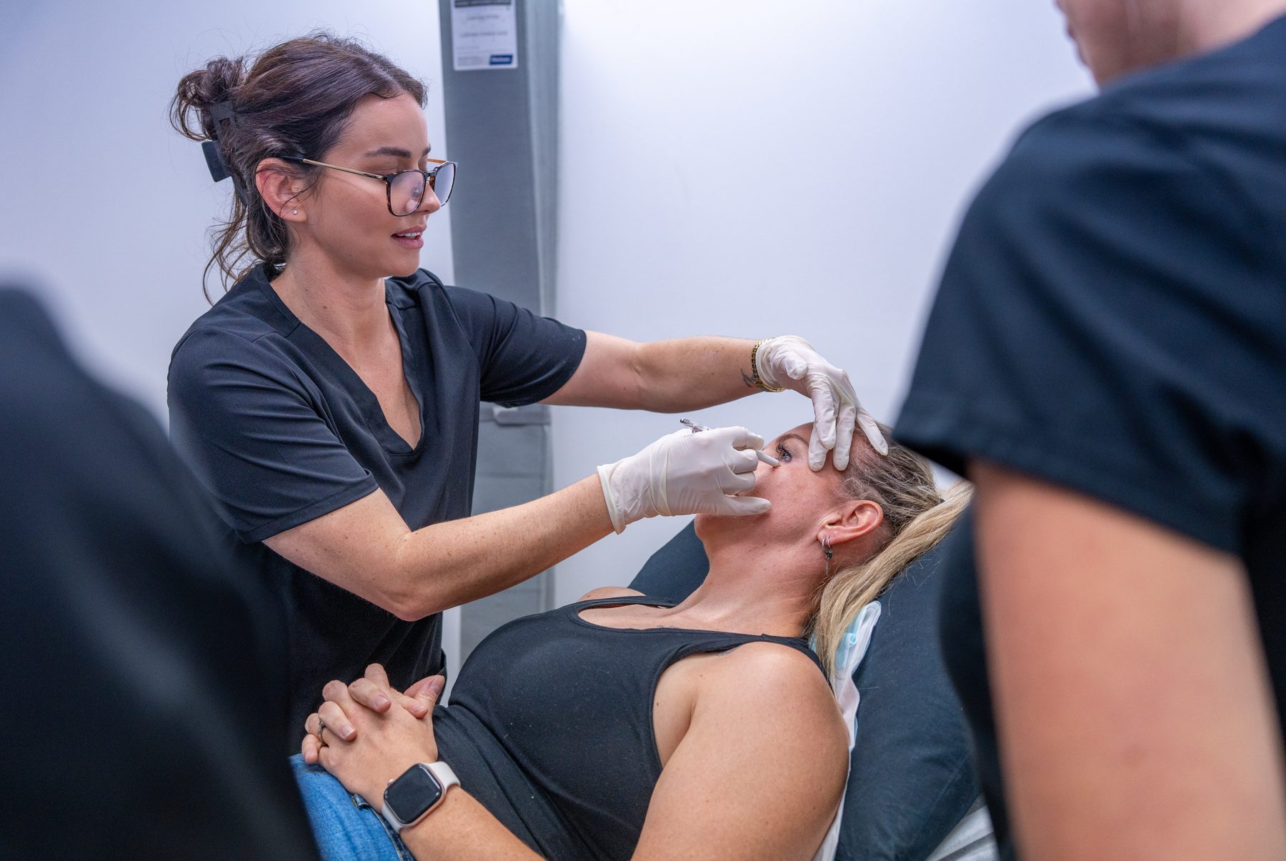 Faculty trainer guiding an anti-wrinkle injection technique